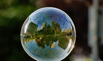 Una ciudad con una zona verde reflejada en una bombolla