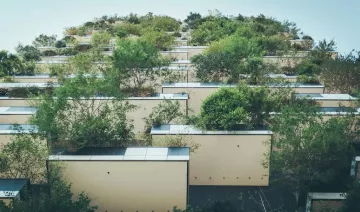 Contrapicado de un edificio con abundantes plantas en los balcones