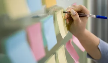 woman-writing-sticky-notes-office-window.jpg