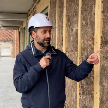 Jordi Martí, arquitecte tècnic i divulgador, assenyalant el sistema d'aïllament tèrmic d'una façana en rehabilitació
