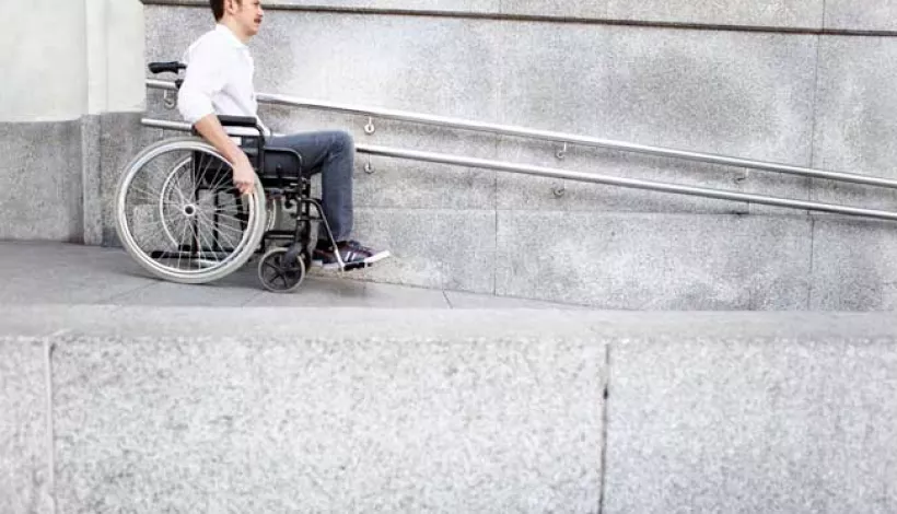 Una persona en silla de ruedas bajando por una rampa