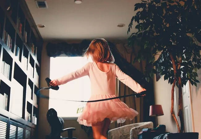 Niña saltando en una cama