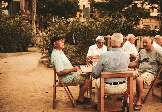 Gente mayor sentados en una zona verde