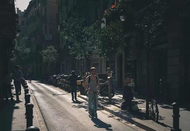 Joven con patinete en una calle de Barcelona