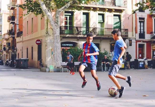 Niños jugando a fútbol en la calle