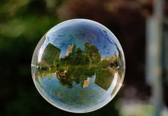 Una ciudad con una zona verde reflejada en una bombolla
