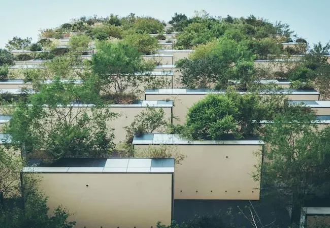 Contrapicado de un edificio con abundantes plantas en los balcones