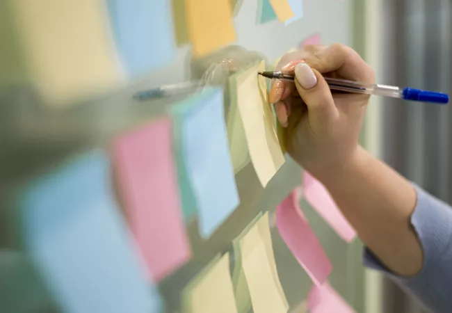 woman-writing-sticky-notes-office-window.jpg
