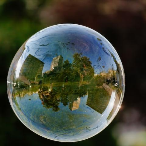 Una ciudad con una zona verde reflejada en una bombolla