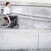 Una persona en silla de ruedas bajando por una rampa